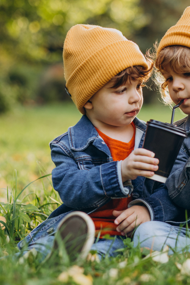 Два маленьких  брата сидят на траве