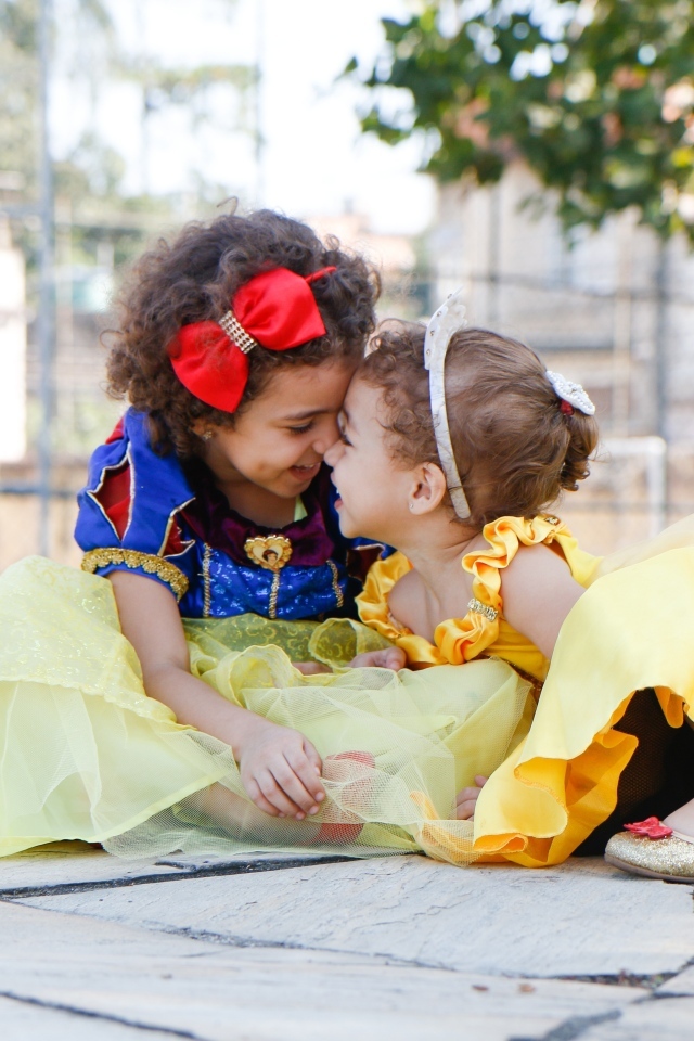 Две маленькие сестры играют под деревом