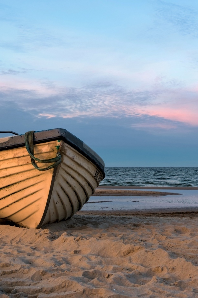 Лодка стоит на песке у моря летом