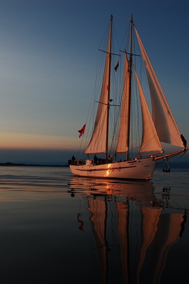 Большая парусная яхта в море на закате