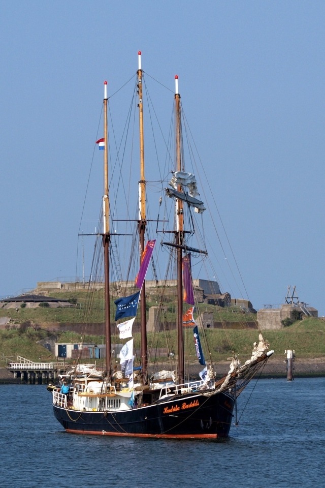 Большой корабль с опущенными парусами в гавани