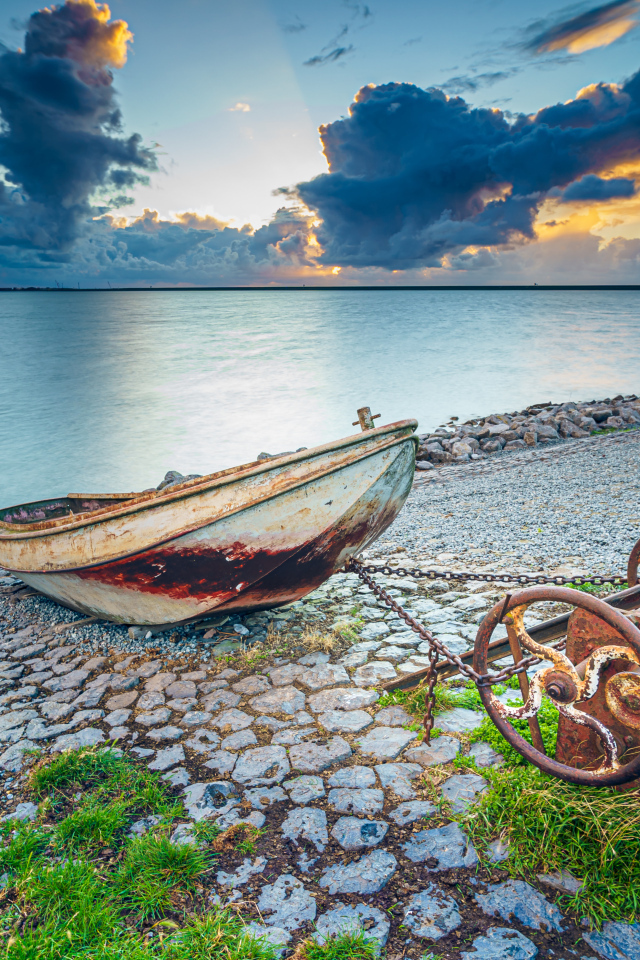 Старая лодка на берегу моря 