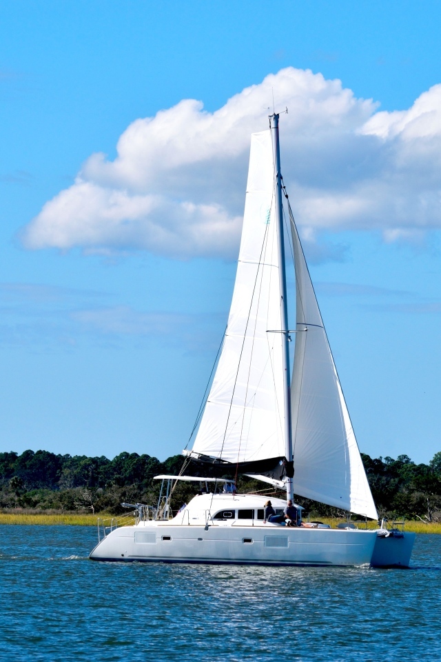 Парусная яхта в море на фоне красивого неба