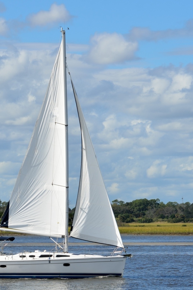 Яхта с белыми парусами на реке