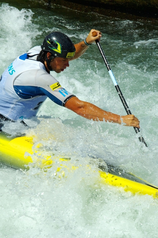 Мужчина на байдарке спускается по бурной реке