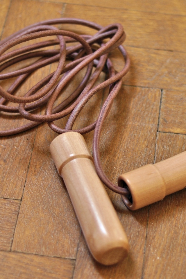 Скакалка лежит на деревянном полу