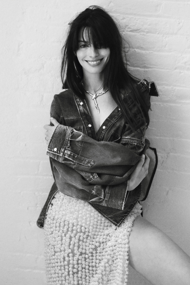 Актриса Энн Хэтэуэй стоит у стены черно-белое фото