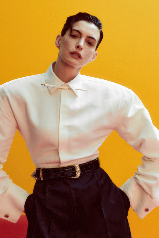 Актриса Энн Хэтэуэй в белой рубашке на желтом фоне