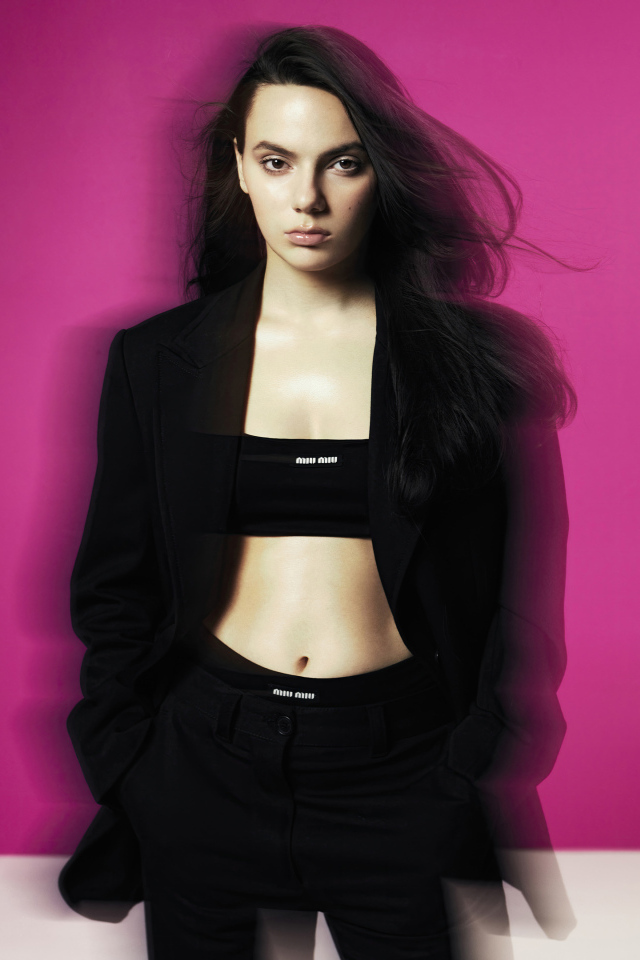 Актриса Дафни Кин стоит у розовой стены