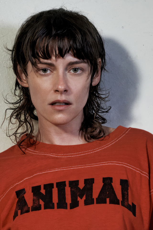 Актриса Кристен Стюарт стоит у серой стены