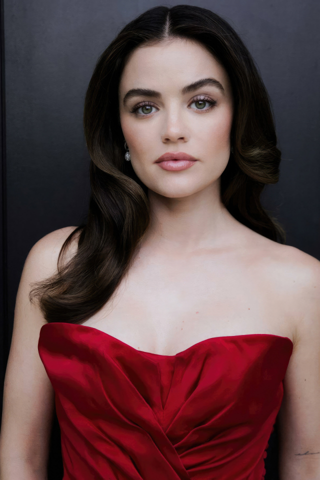 Актриса Люси Хейл в красном платье у серой стены