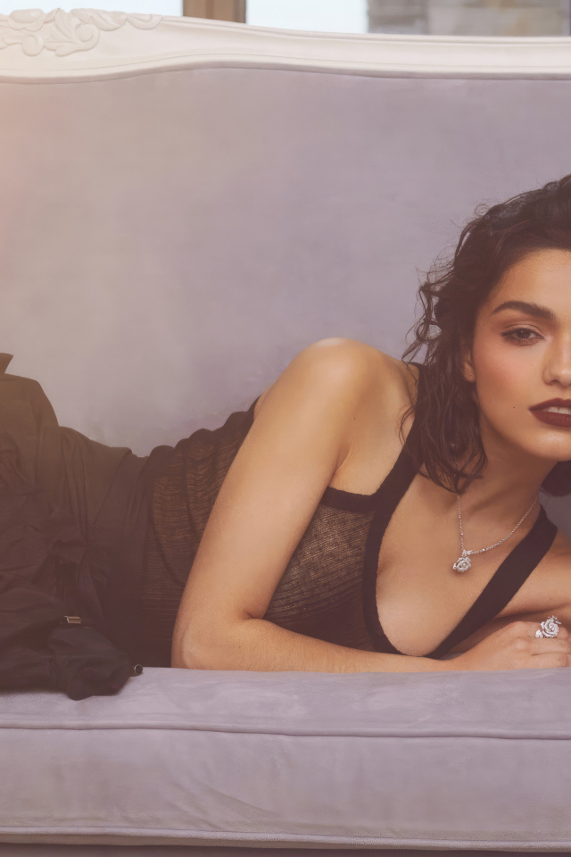 Актриса Рэйчел Зеглер в черном платье лежит на диване