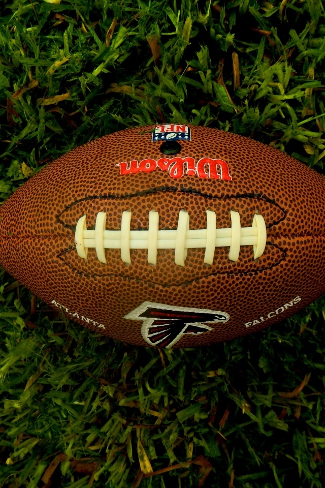 Мяч для игры в американский футбол на зеленой траве