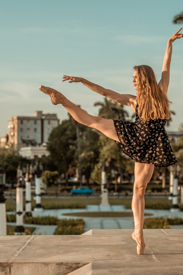 Балерина в лучах солнца у стены