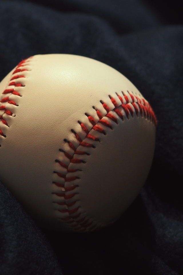 Бейсбольный мяч на черной ткани 