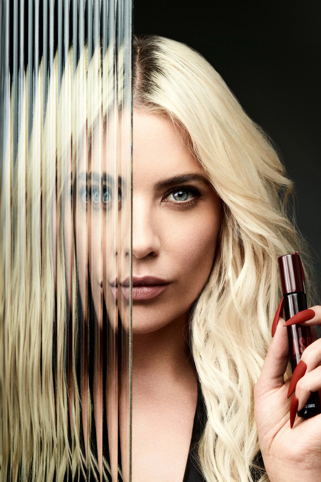 Блондинка Эшли Бенсон стоит за стеклом