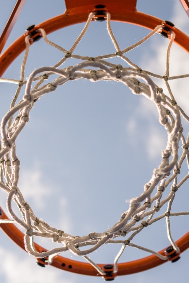 Вид снизу на баскетбольное кольцо на фоне неба