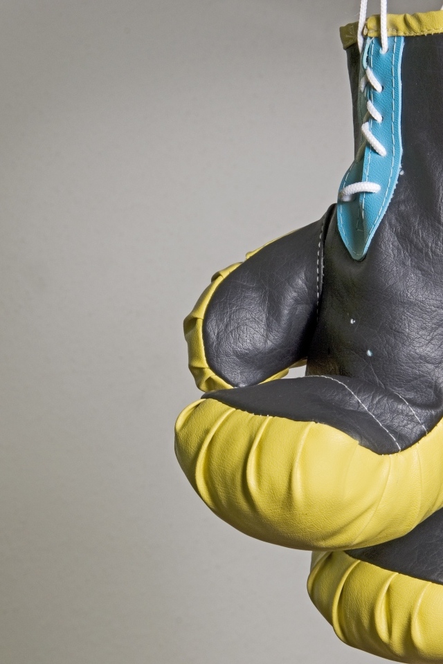 Боксерские перчатки на фоне серой стены 