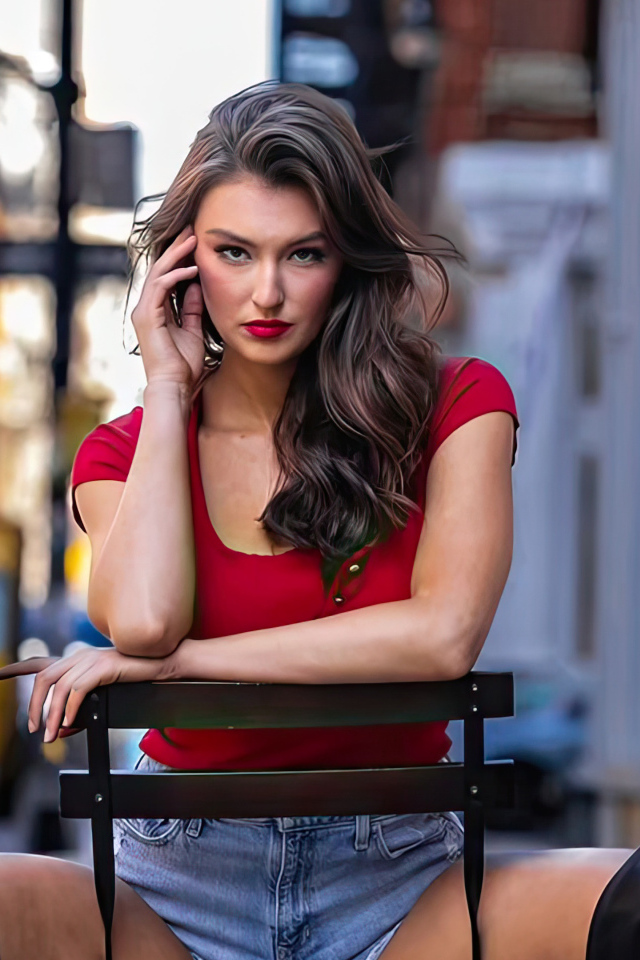 Яркая девушка Рейчел Пиццолато сидит на стуле