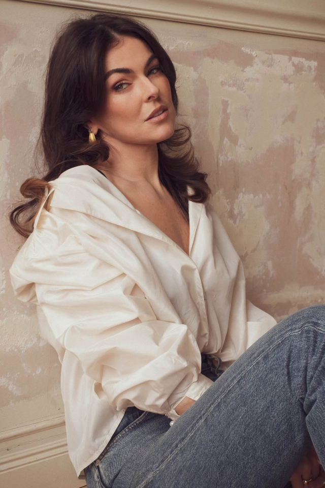 Канадская актриса Серинда Суон сидит у стены