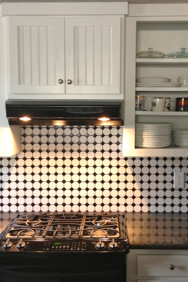 Электрическая плита в кухне с белым гарнитуром