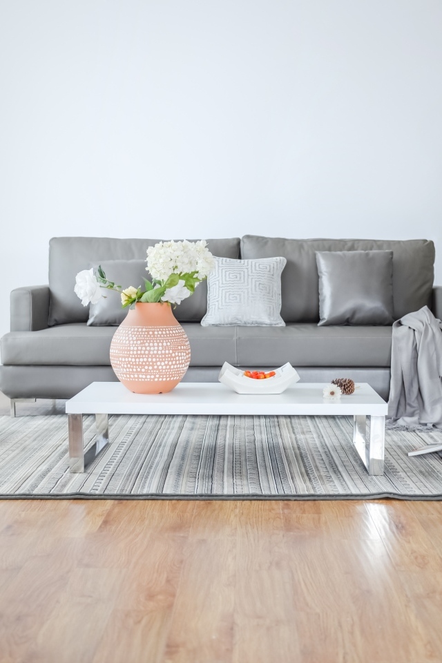 Серый диван в комнате в стиле минимализм