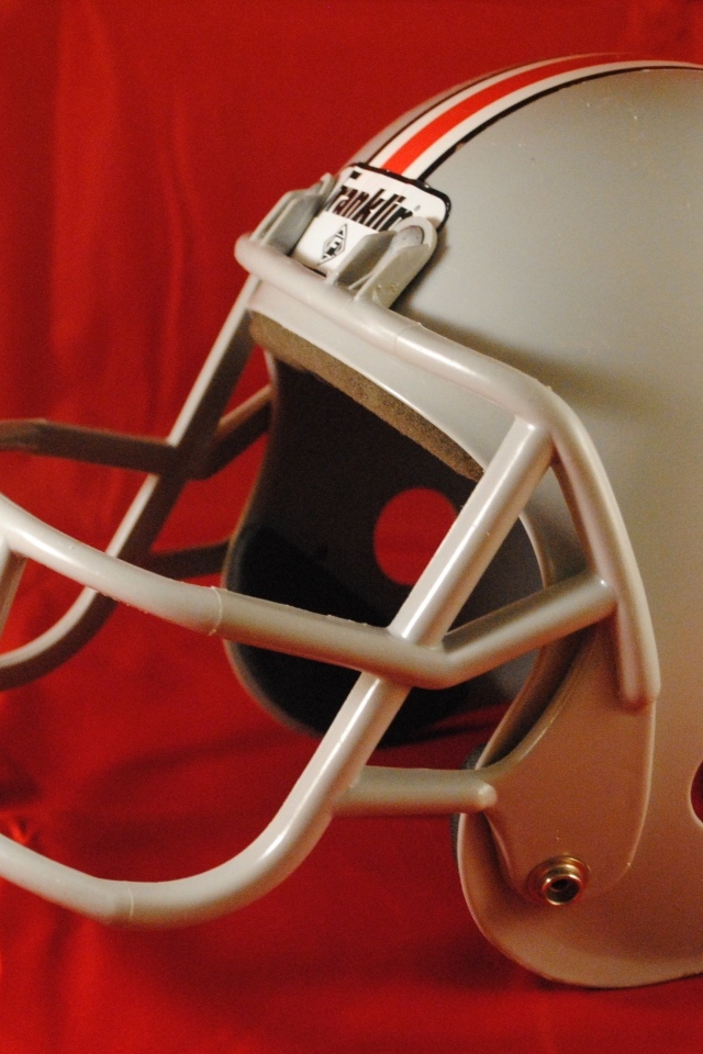 Шлем для игры в американский футбол на красном фоне