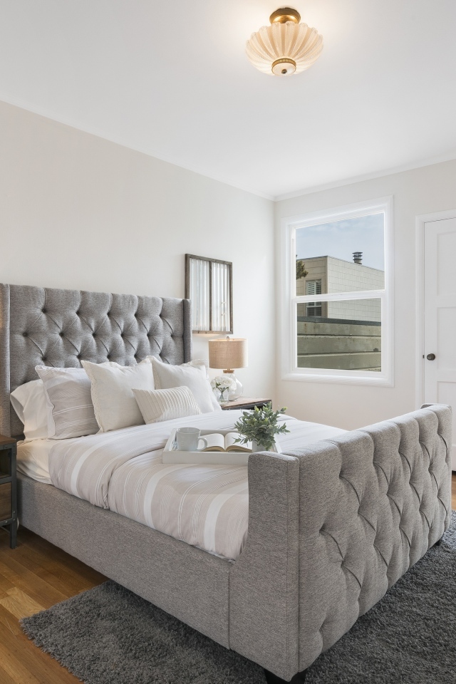 Высокая серая кровать в спальной комнате