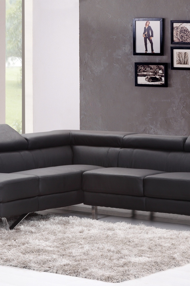 Большой серый диван в комнате с фотографиями на стене 