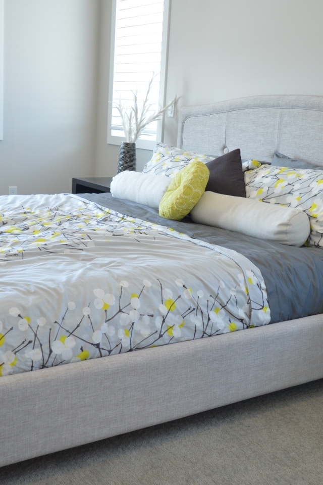 Большая мягкая кровать в серой спальне