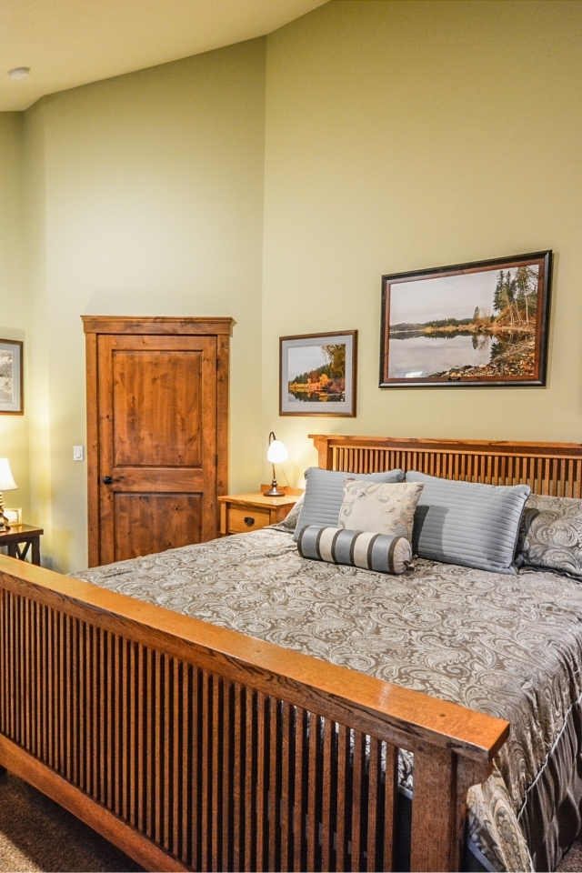 Большая деревянная двуспальная кровать в комнате