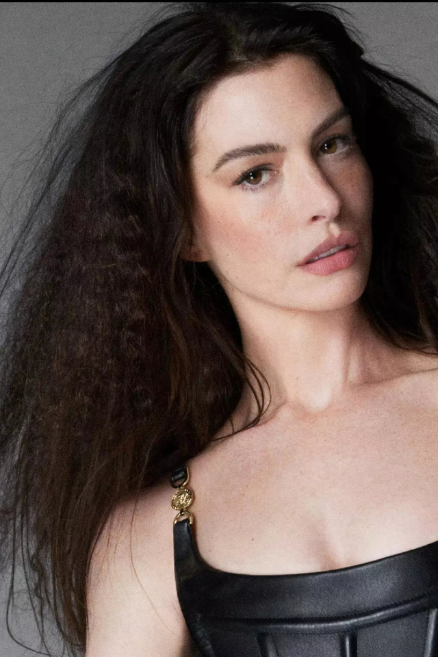 Длинноволосая актриса Энн Хэтэуэй на сером фоне