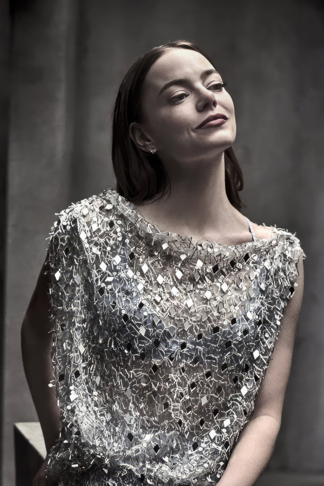 Рыжеволосая актриса Эмма Стоун в блестящем платье в серой комнате