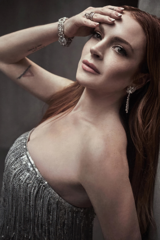 Рыжеволосая актриса Линдси Лохан стоит у стены