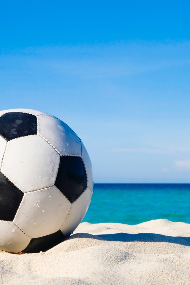 Футбольный мяч на горячем песке у моря