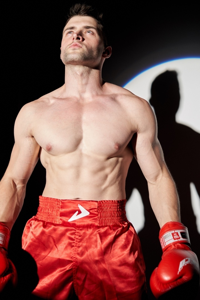 Сильный мужчина боксер в свете софитов