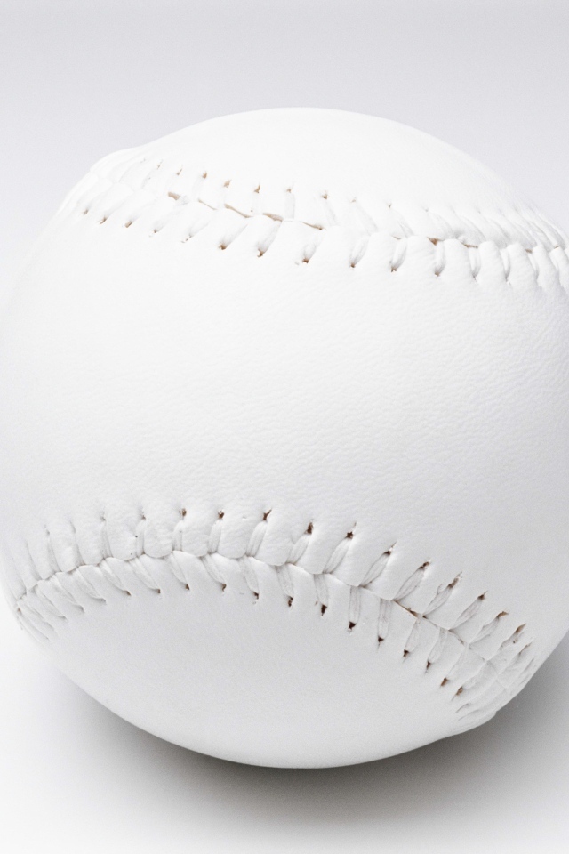 Белый новый бейсбольный мяч на сером фоне