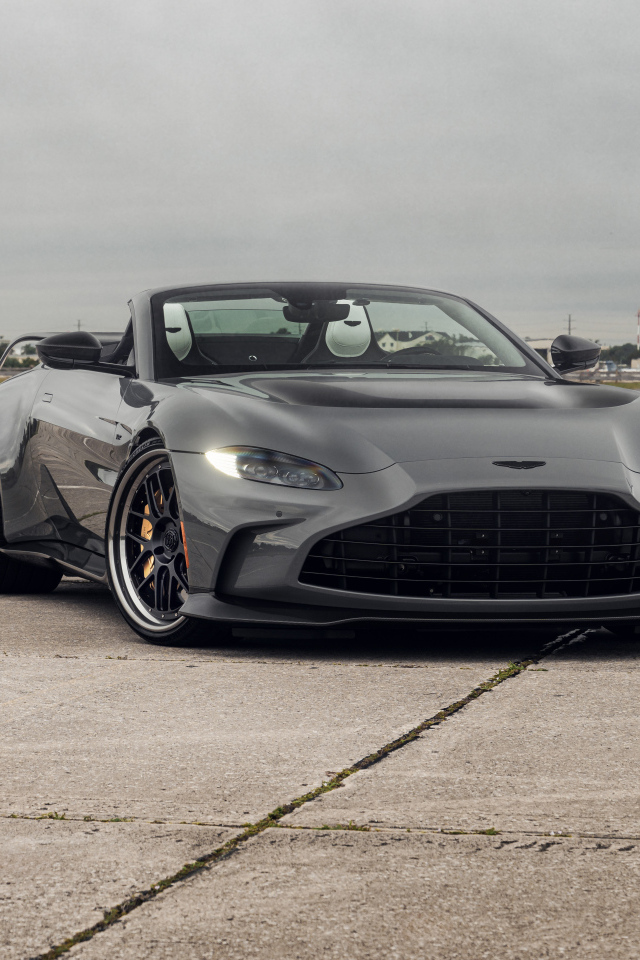 Серый автомобиль Aston Martin Vantage V12 Roadster на взлетной полосе