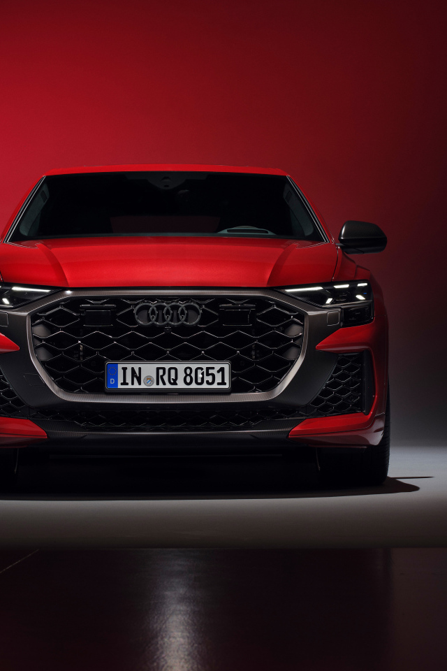 Вид спереди на автомобиль Audi RS Q8 performance 2024 года на красном фоне