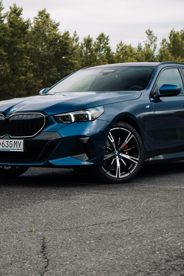 Синий автомобиль BMW 520d xDrive Touring M Sport 2024 года