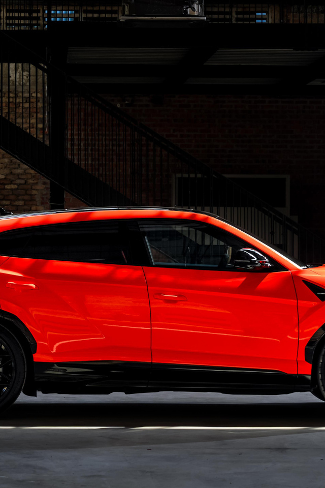 Вид сбоку на красный внедорожник Lamborghini Urus