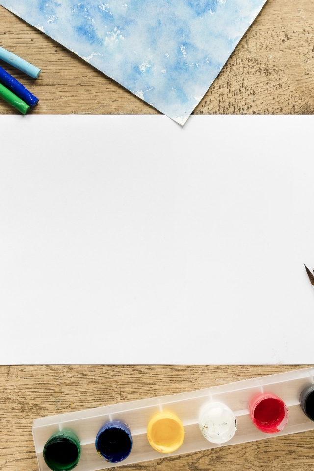 Предметы для рисования с листом бумаги на столе