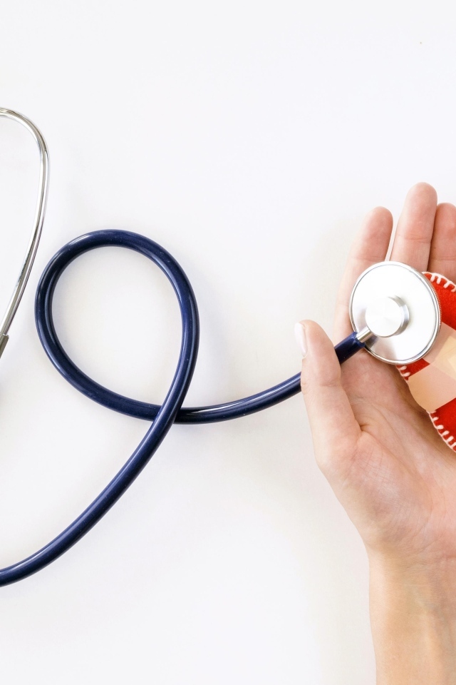 Стетоскоп слушает раненое сердце в ладонях