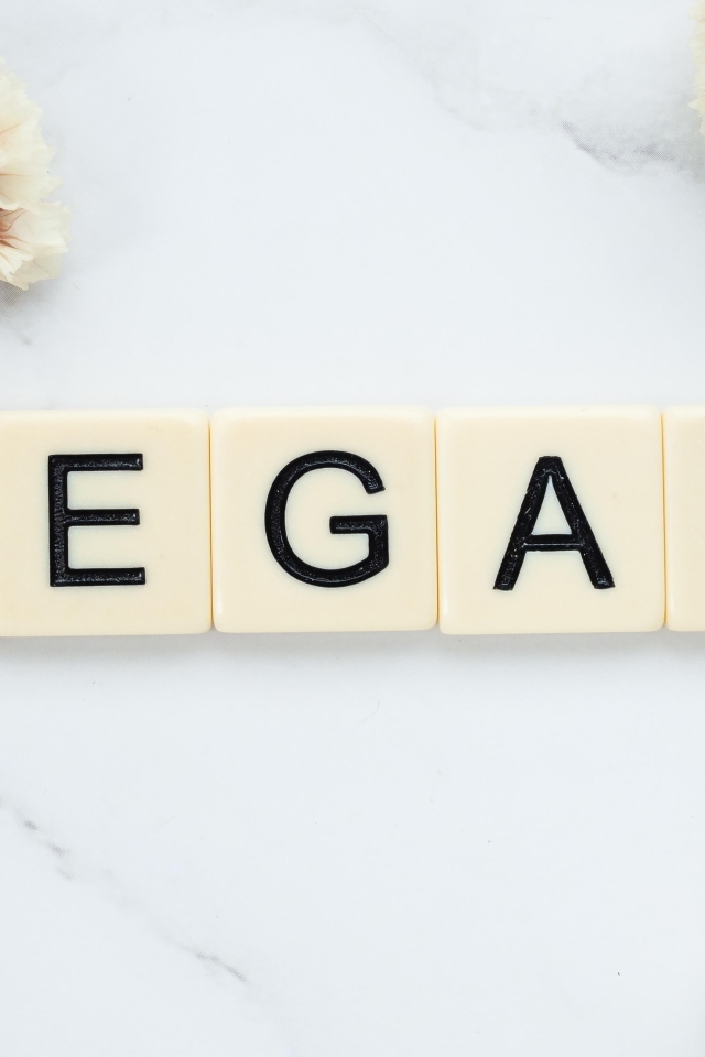 Надпись веган на столе с цветами