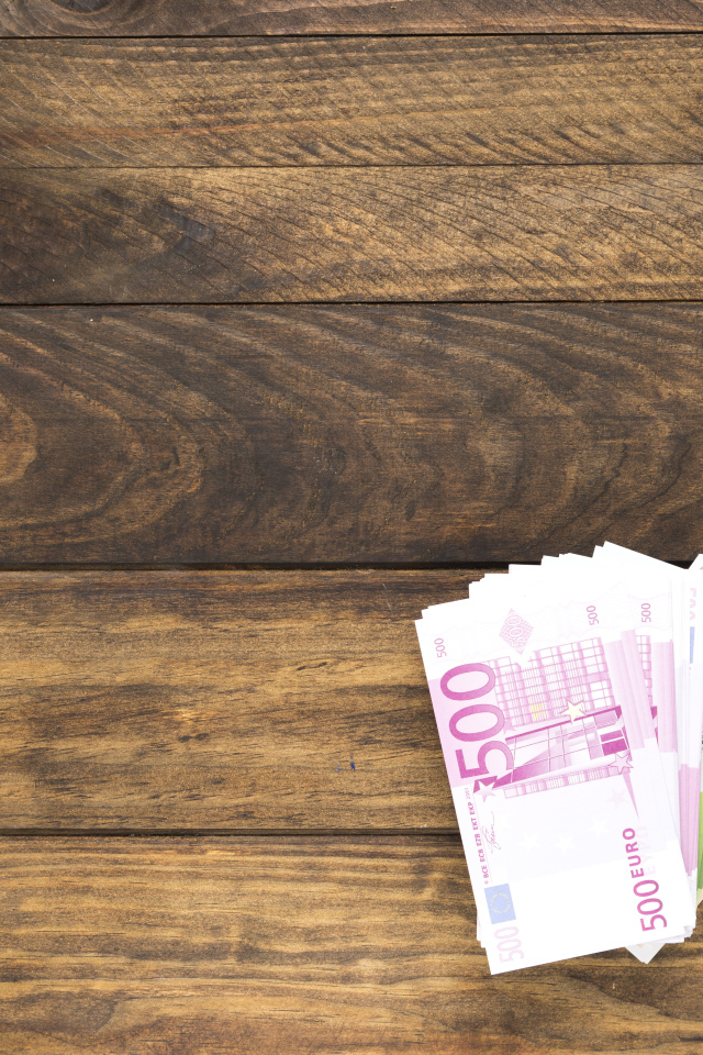 Купюры и калькулятор на деревянном фоне