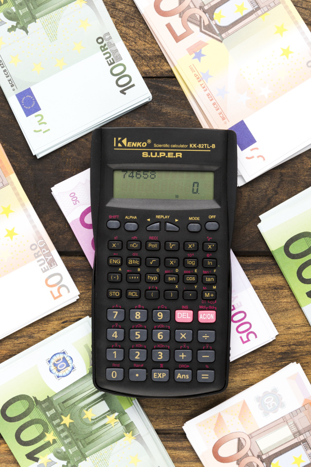 Калькулятор и купюры евро на деревянном столе