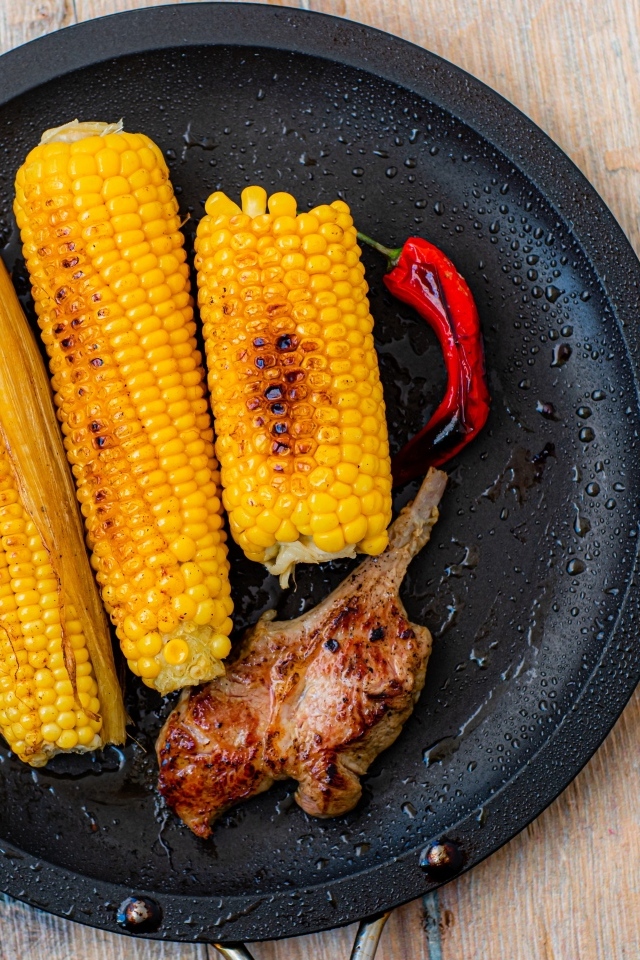 Запеченная кукуруза с ребрышками на тарелке