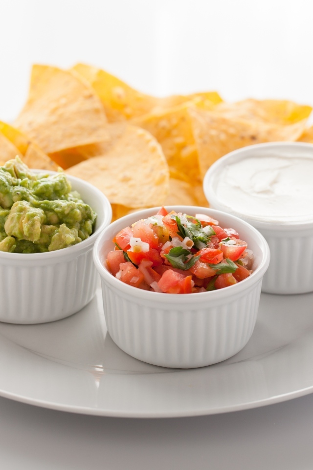 Чипсы с соусом на большой белой тарелке