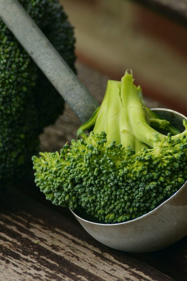 Зеленое брокколи с половником на столе
