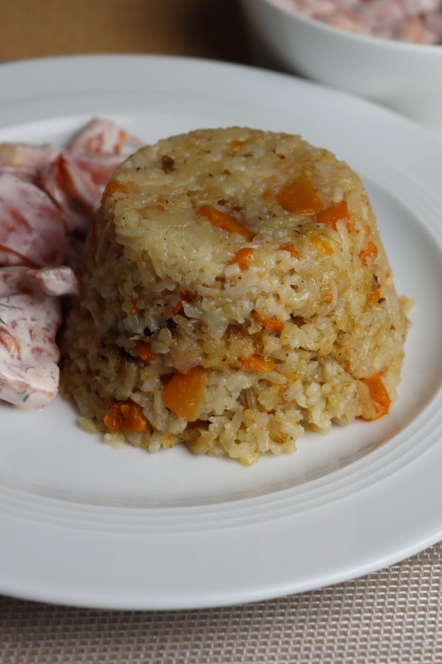 Рис с салатом на большой белой тарелке